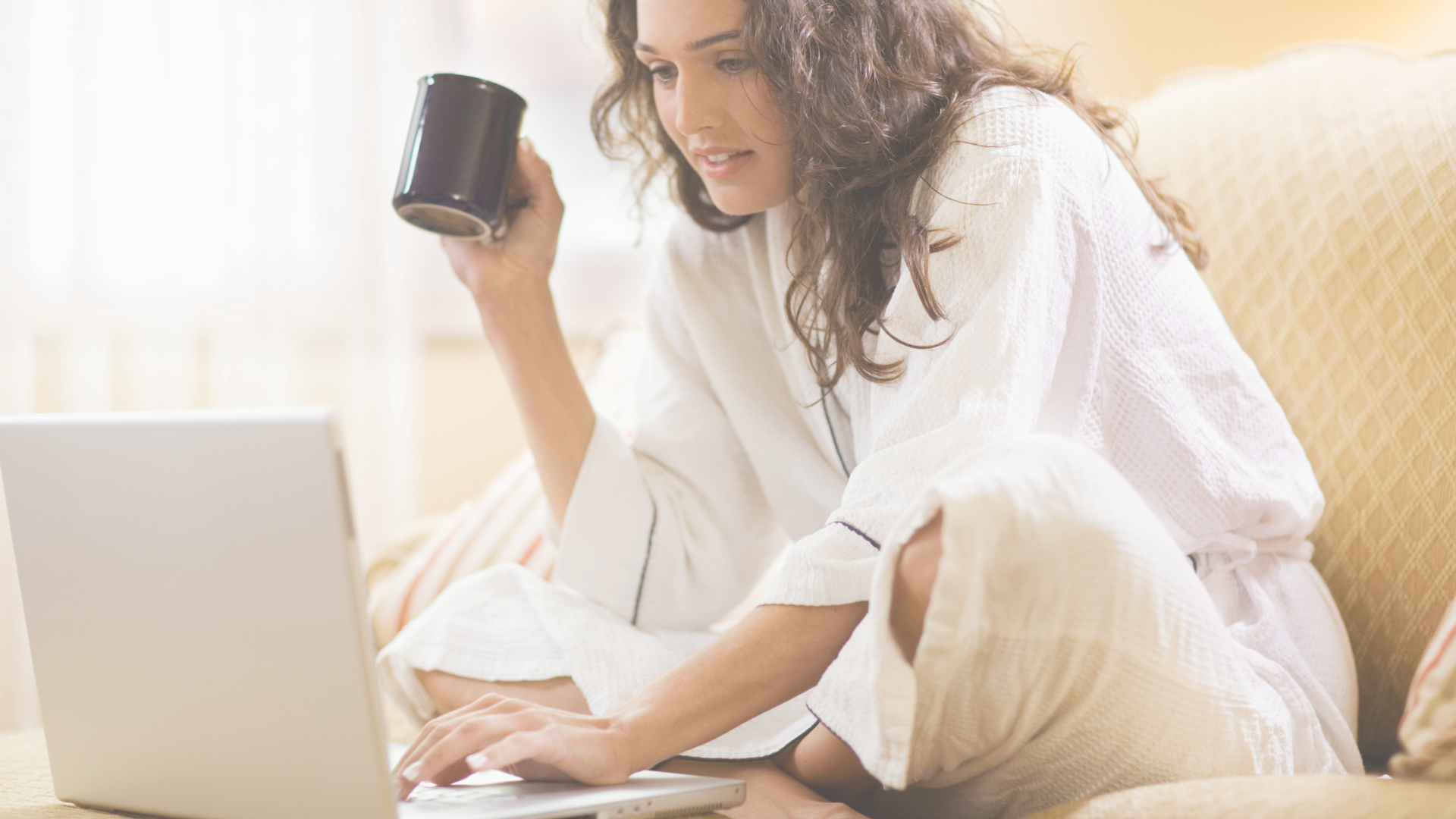 Woman sitting on a sofa working on a laptop